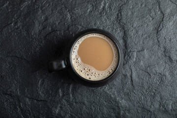 A black cup of coffee on a dark background