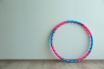 Hula hoop near light wall in gym. Space for text © New Africa