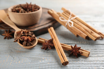 Fototapeta premium Aromatic cinnamon sticks and anise on grey wooden table