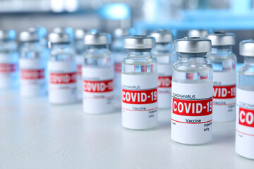 Glass vials with COVID-19 vaccine on light table