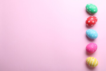 Bright painted eggs on pink background, flat lay with space for text. Happy Easter