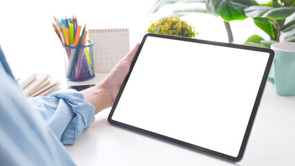 Close up of man hand holding digital tablet with blak screen on working table background for mock up, template