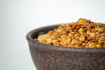 GRANOLA EM TIGELA DE MADEIRA EM FUNDO BRANCO