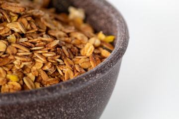 GRANOLA EM TIGELA DE MADEIRA EM FUNDO BRANCO