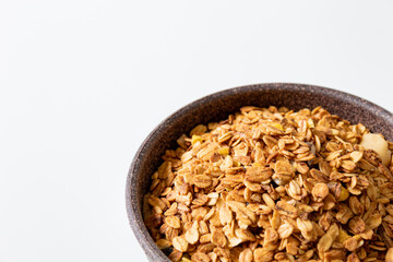 GRANOLA EM TIGELA DE MADEIRA EM FUNDO BRANCO