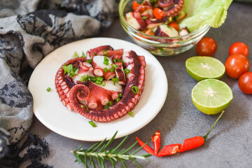 Octopus salad vegetables with lemon lime tomatoes chili herbs and spice on plate and bowl, Fresh and healthy salad seafood squid and octopus tentacles