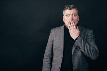 Troubled worried shocked man over black background