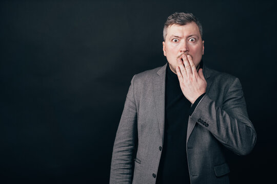 Troubled worried shocked man over black background