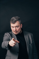 Businessman pointing finger looking at camera