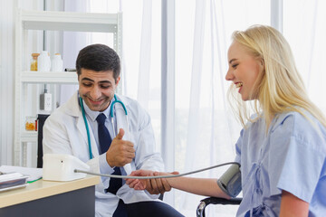 male doctor talked to a female patient with a thumbs up about the improvement of his condition