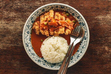 Top view of Fried chicken curry rice on wooden table.