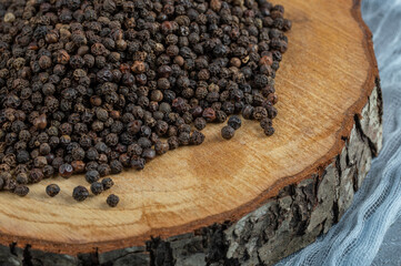 A wooden board full of dried peppercorns
