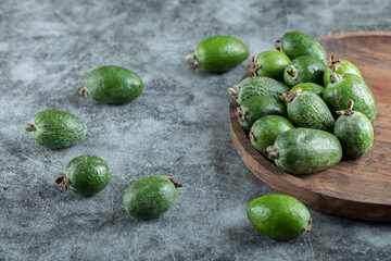 A wooden cutting board with fresh feijoa