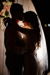 silhouette of the newlyweds in the dark. shooting at night.