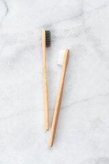 Two bamboo toothbrushes on marble background. Dental and healthcare concept. Top view, flat lay. - 416192368