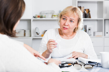 Obraz premium Mature woman consults with a financial adviser for the proper conduct of home accounting