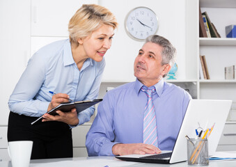 Mature director's assistant makes daily routine and planning meeting at office