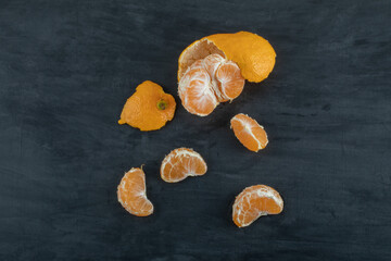 Slices of sour tangerine on a dark background