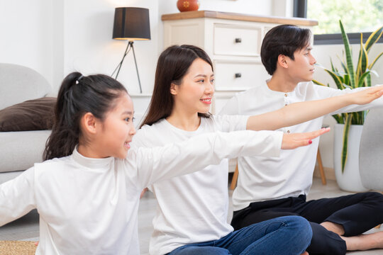 Young Asian family doing exercise together at home