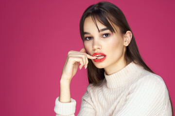 Woman with red lips bright makeup white blouse long hair pink background