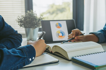 Group high school teenage students are studying, learning online academic lesson in university library, home or house, reading book and taking notes with classmate. Concept of education in college.