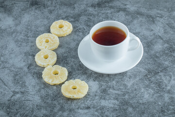 A cup of aroma tea with dried pineapple