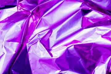 neon crumpled holographic abstraction in bright pink and purple, selective focus, blur