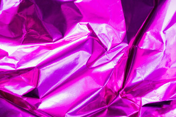 neon crumpled holographic abstraction in bright pink and purple, selective focus, blur