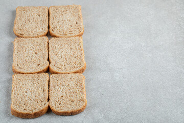 Many of slices of brown bread on a gray background