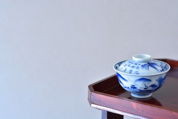 picture rice bowl. put on a Japanese lacquer serving tray. This is a very fine example of Japanese traditional antique “ imari ware ”. blurred background soft focus image. 日長風暖 柳青々 北雁帰 飛入窅冥・賈至