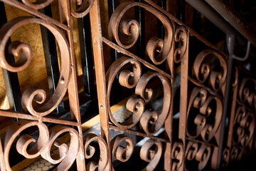 A view of an antique iron staircase railing design with dramatic dark lighting.
