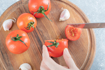 Fresh tomatoes with garlic on a wooden board