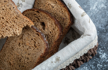 A wooden basket with slices of brown bread