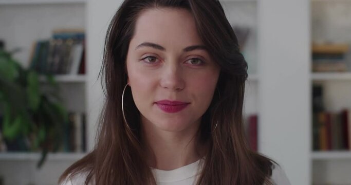 Close up portrait of nice-looking Caucasian woman looking into camera slow motion. Smiling girl with make up lipstick posing indoors slow motion. Confidence female cosmetics fashion beauty concept
