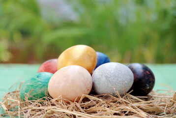 easter basket with easter eggs on wooden background