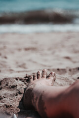 A foot on the sand at the beach.
Un pie sobre la arena en la playa.