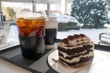 Two refreshing coffees with chocolate cake on the table with bright sunshine.
