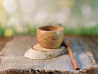 Oak table with visible growth rings stands on a wood cup. On a jute napkin, it lies on a birch pad 