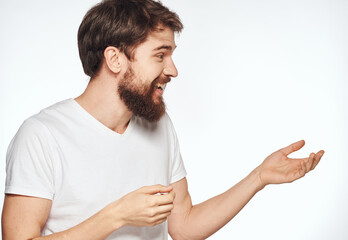Emotional man on a light background gesturing with his hands cropped view