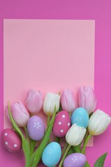Easter holiday.Pink and white tulips flowers and blue Easter decorative eggs on a pink background. Easter festive background in pastel colors. copy space.Spring Religious Holiday Symbol