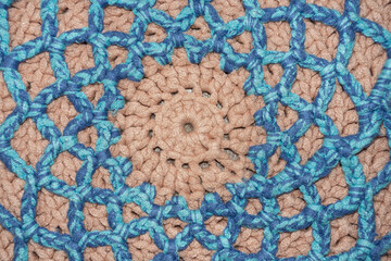 Cute home-made symmetrical pattern of thick thread, made with your own hands: handmade rug made of pink and blue thread, woven pattern, village traditions, knitting art