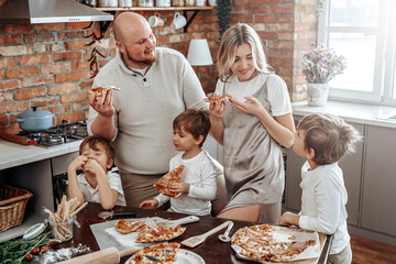 Warm portrait of a happy and young family they taste a domestic pizza. Loving couple and their...