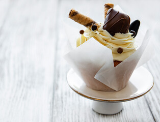 Chocolate cupcake on white wooden background
