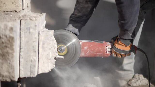 Side view of spinning angle grinder with diamond blade cutting concrete