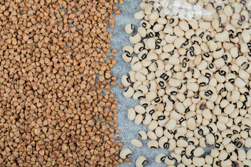 Raw buckwheat with white kidney beans on a gray background