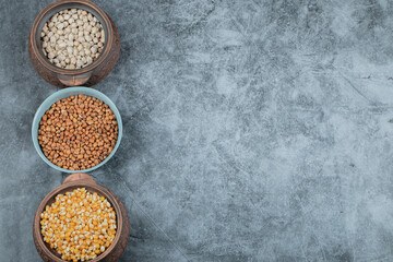 Different kinds of raw beans on a gray background