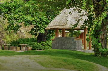 Fototapeta na wymiar a gazebo in the shade of trees on a well-kept lawn. Vietnamese fresh green garden.