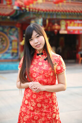 Naklejka premium beauty woman wear red cheongsam looking and smile in chinese new year