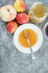 Peaches, jam and cup of tea on marble table