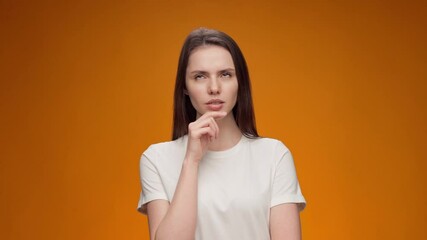 Young woman thinking about her problem, came up with the idea, against yellow background